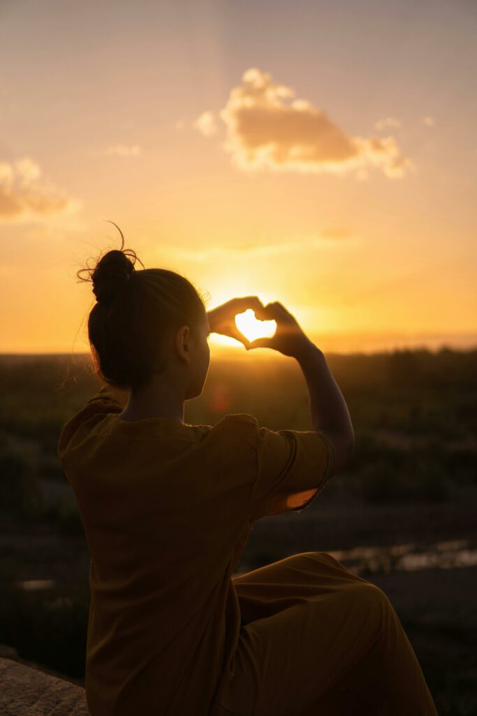 pexels-photo-1535288-1535288 Silhouette of a person forming a heart with hands against a Morocco sunset.